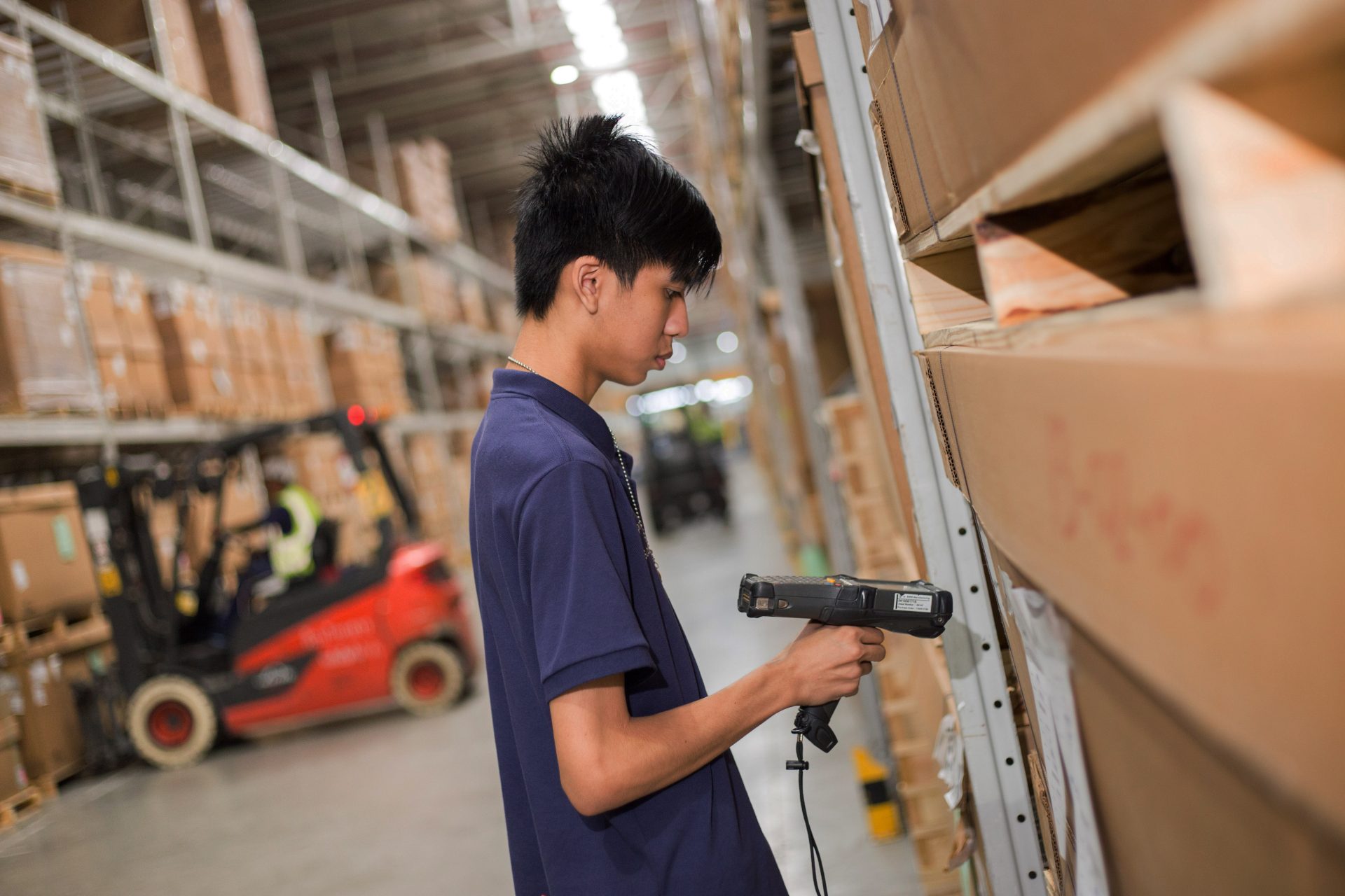 Apprentice working in logistics with hand scanner