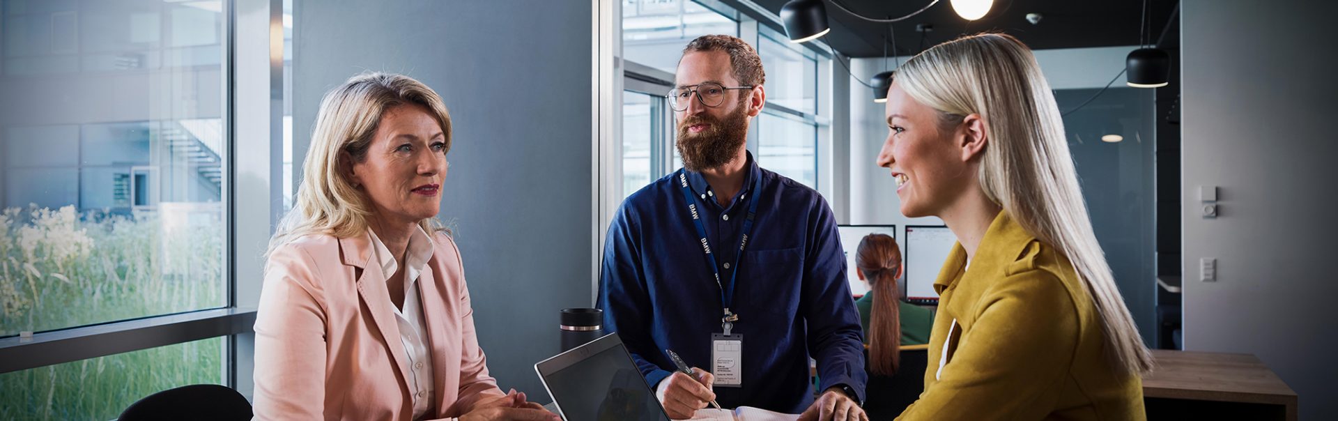 The image shows a meeting situation between BMW Group colleagues.