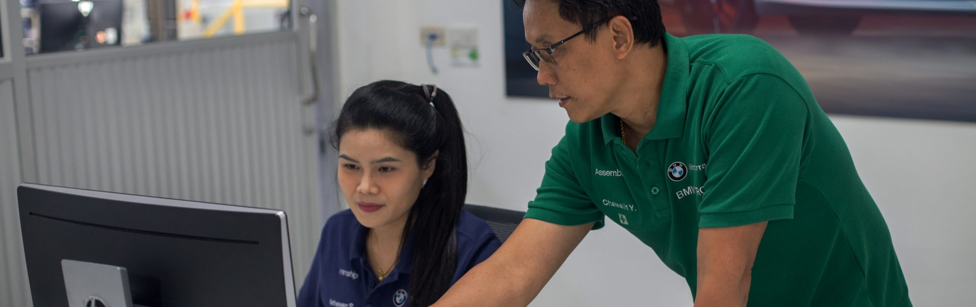 Student working with trainer on computer.