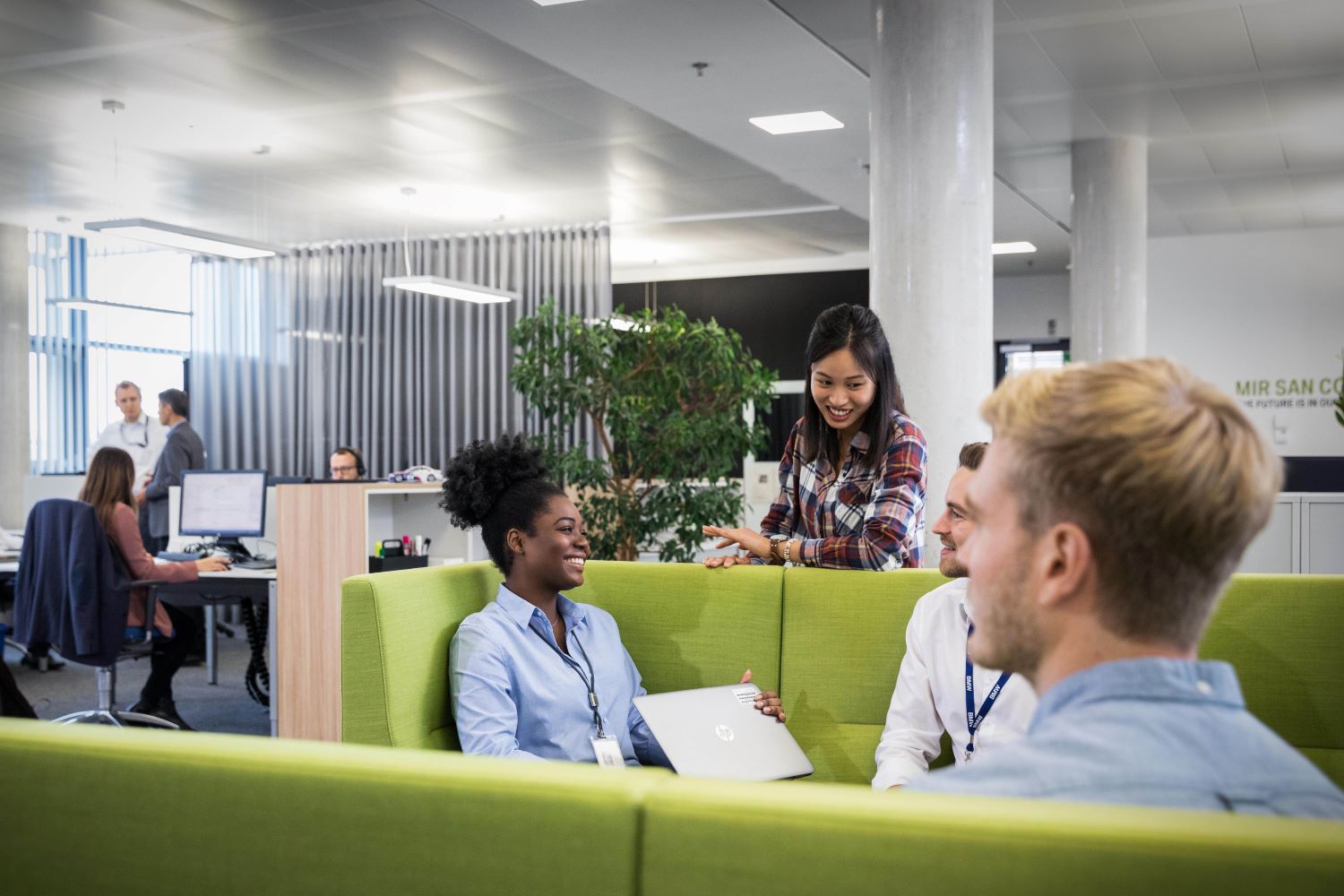 A group of students having a fun conversation in an innovative office environment.