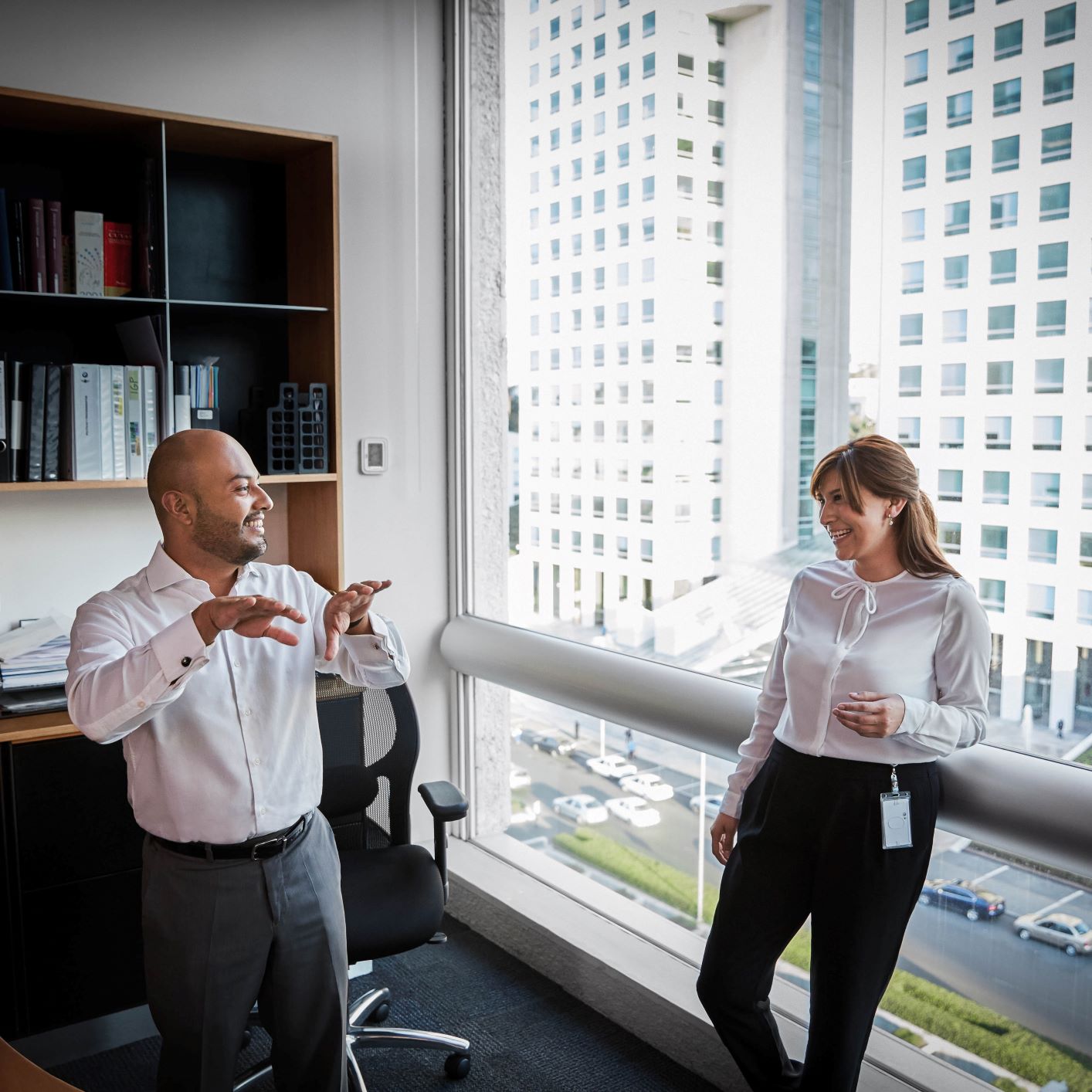 Two marketing employees, a man and a woman, are having a discussion in an office.