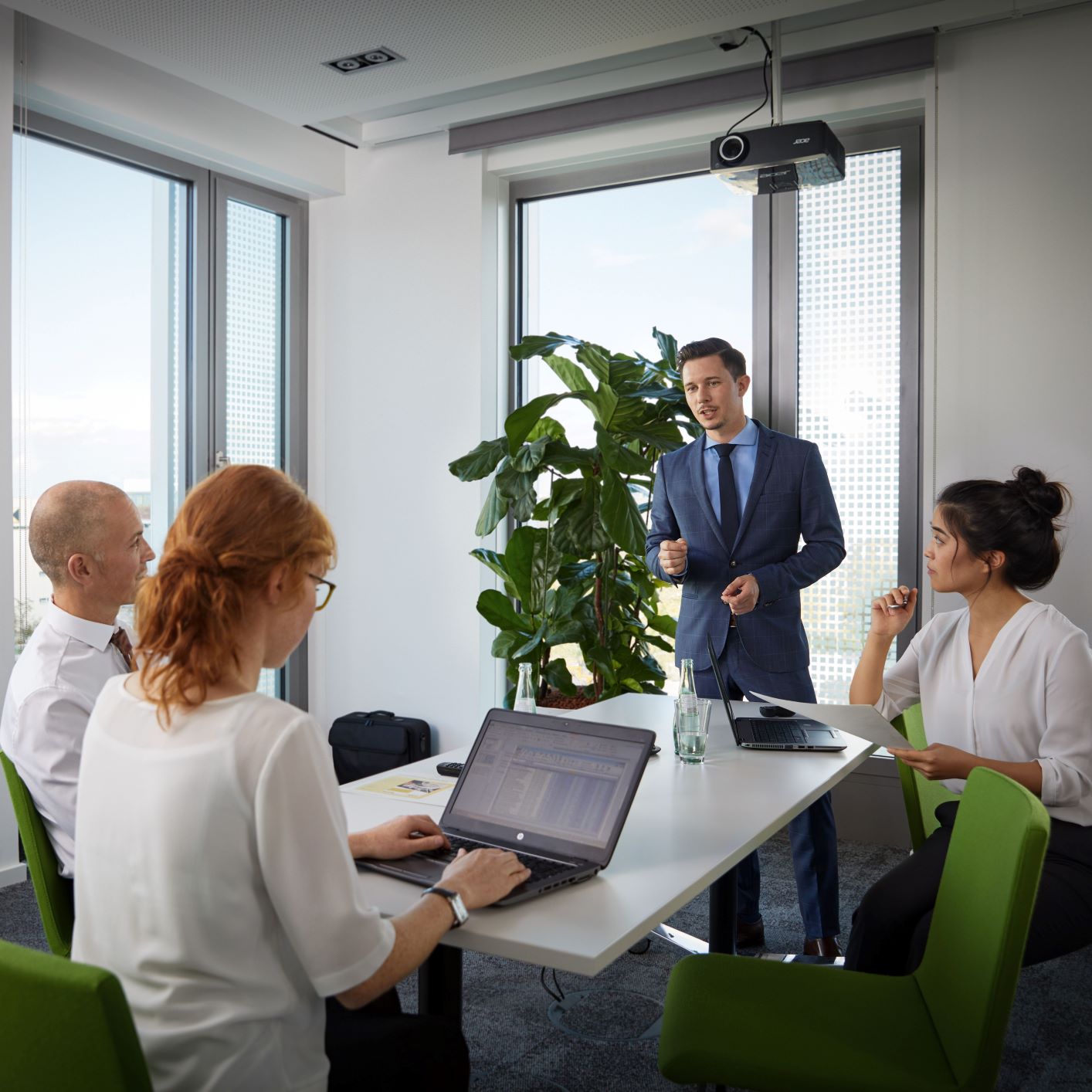 A male BMW risk management professional explains something during a meeting.