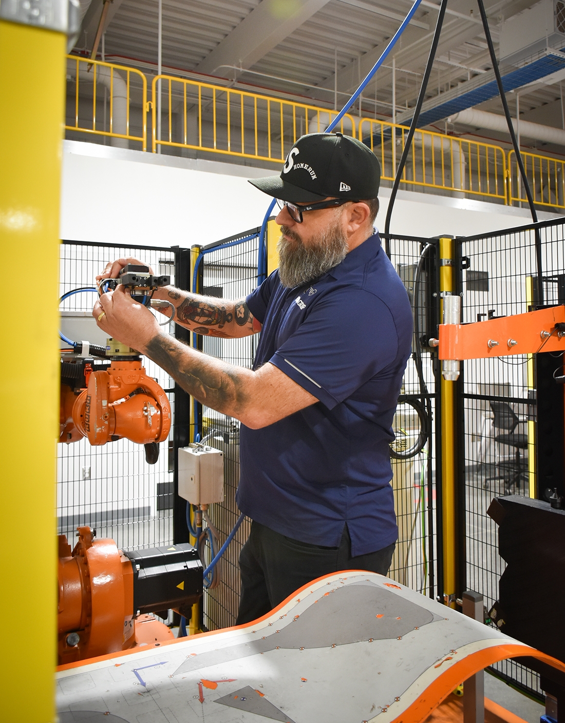 Portrait of BMW Group Maintenance Employee Luciano working with a production robot
