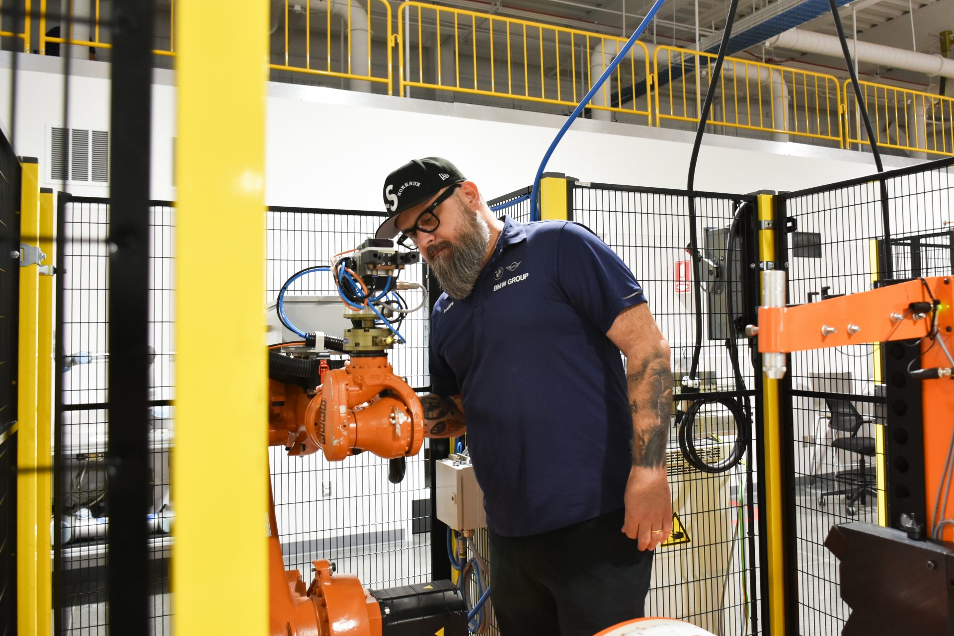 Portrait of BMW Group Maintenance Employee Luciano working with a production robot