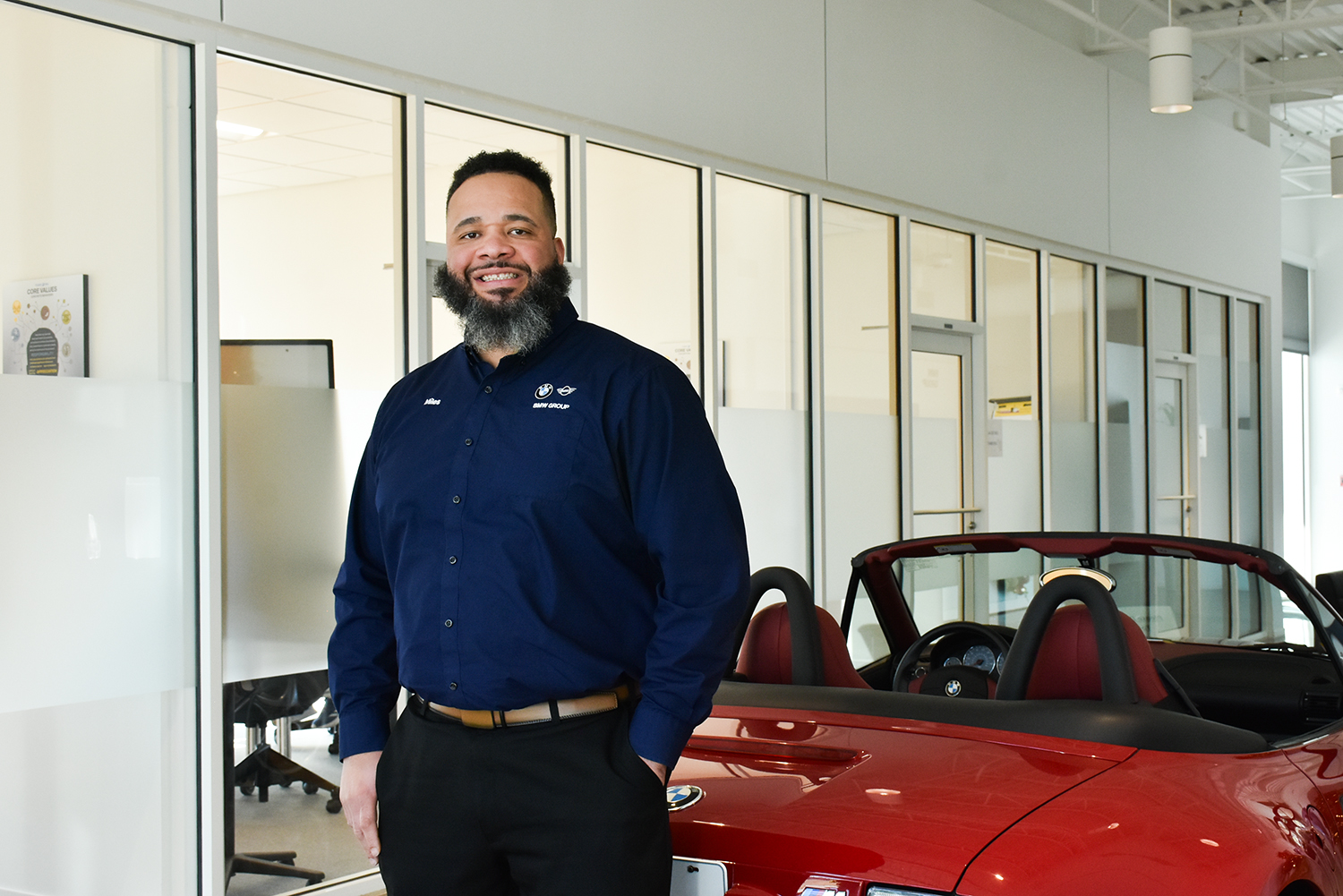 BMW Group Maintenance Employee Miles standing in front of a red BMW Z3