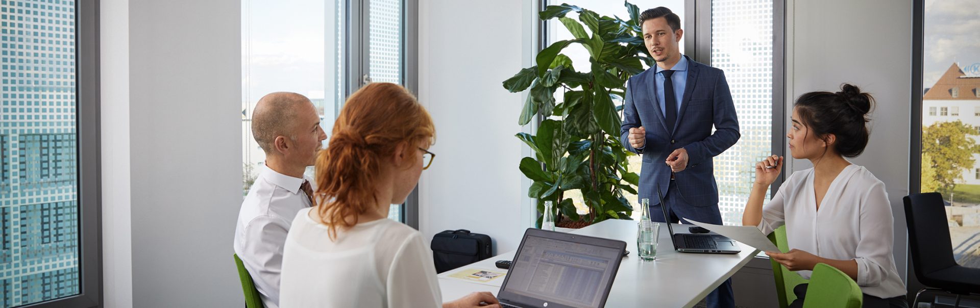 Four risk management employees in a meeting at a large table