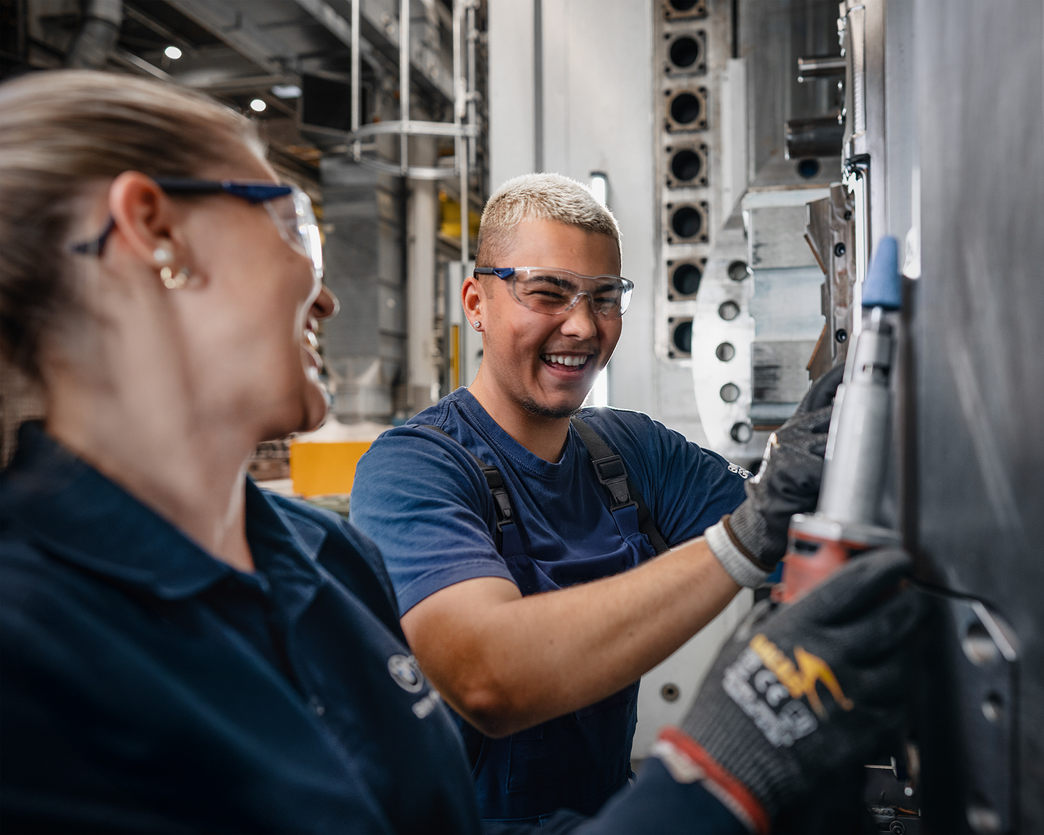 Two young employees are working at the assembly line.