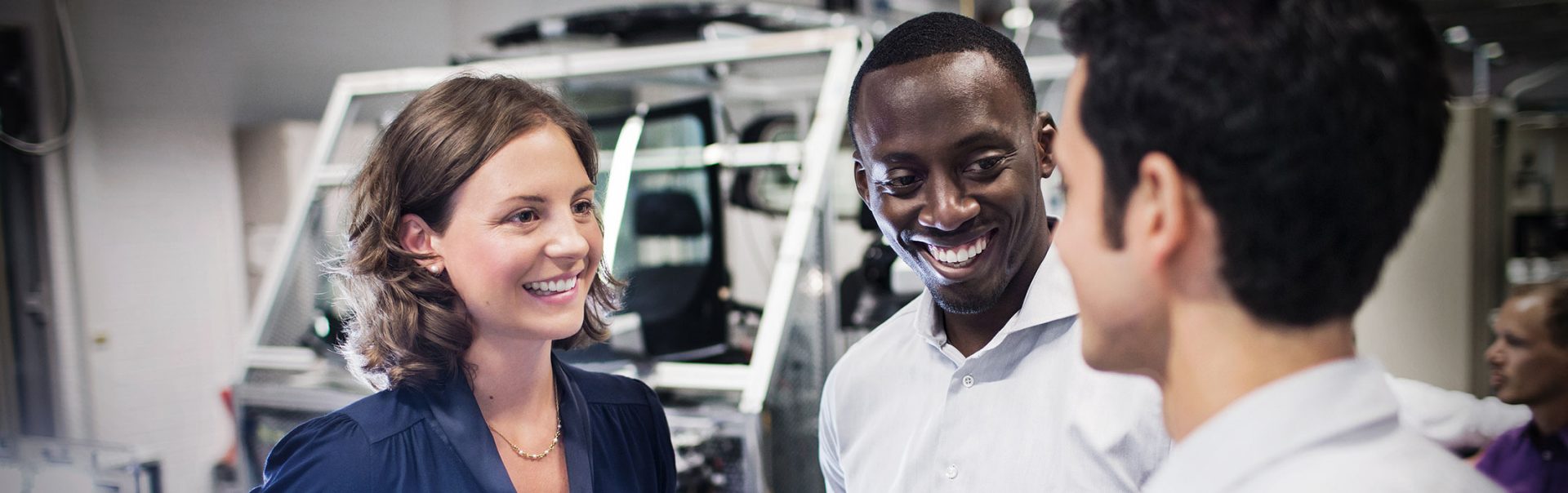 Three colleagues at the BMW Group are having a conversation