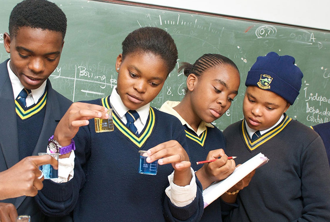 Four kids doing experiments at school