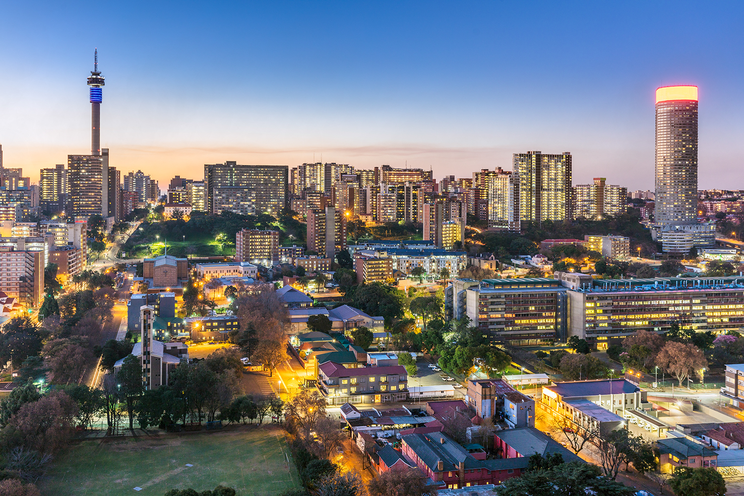 Johannesburg cityscape panorama sunset with the residential hillbrow suburb and the iconic Telkom communication tower to Ponte tower. Johannesburg is one of the forty largest metropolitan cities in the world, and the world's largest city that is not situated on a river, lakeside, or coastline. It is also the source of a large-scale gold and diamond trade, due being situated in the mineral-rich Gauteng province.