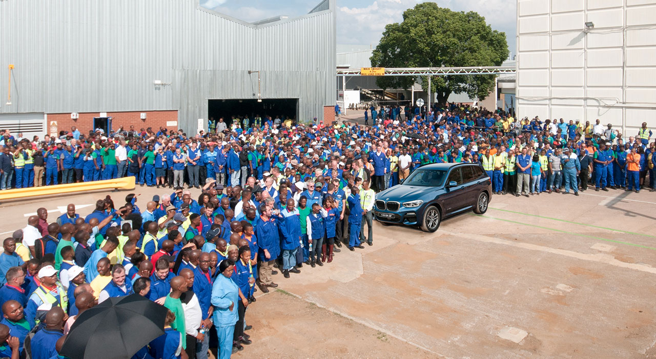 The picture shows a large group of BMW Group employees outside at a BMW plant in South Africa.