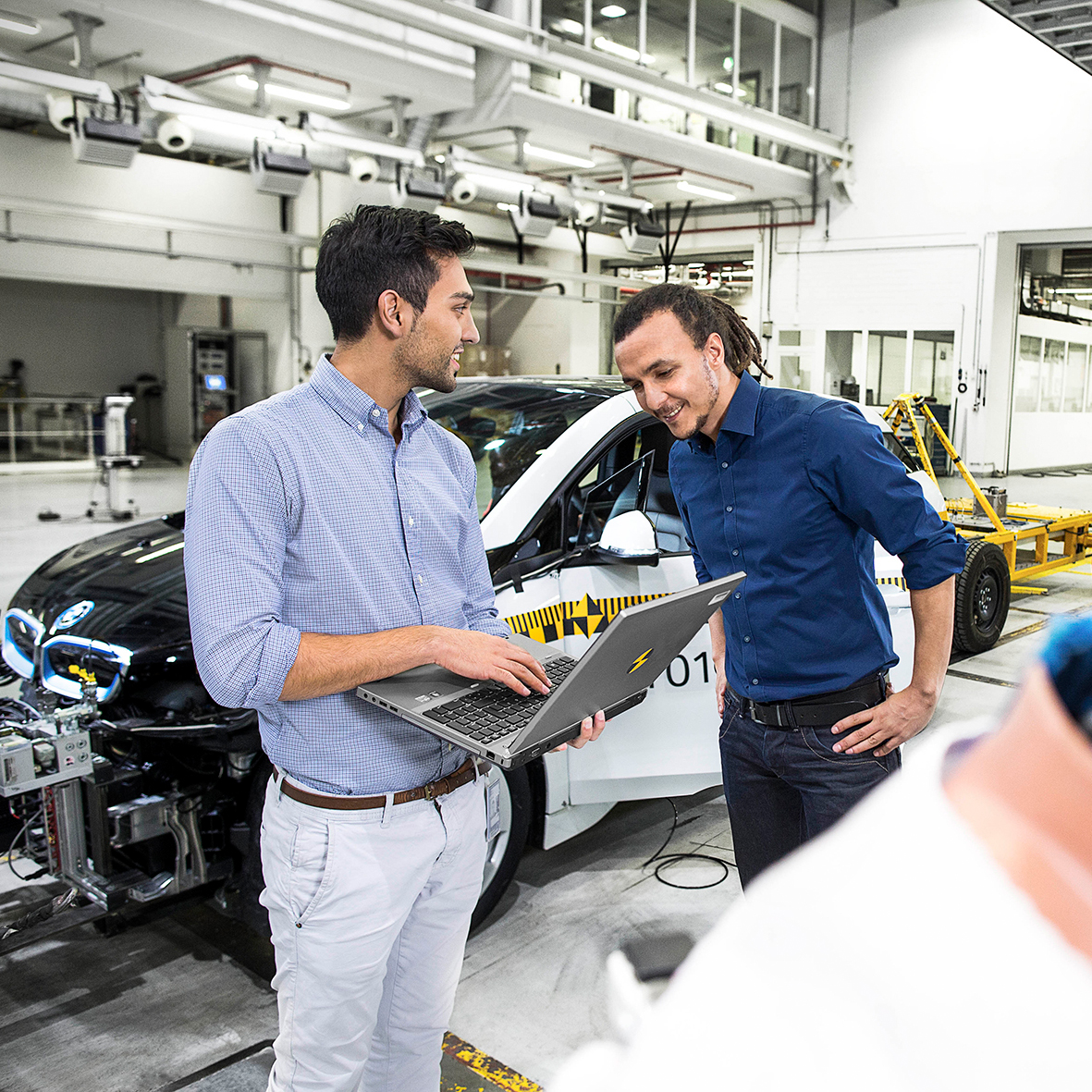 Das Bild zeigt zwei BMW Doktoranden in einer Crashtesthalle.
